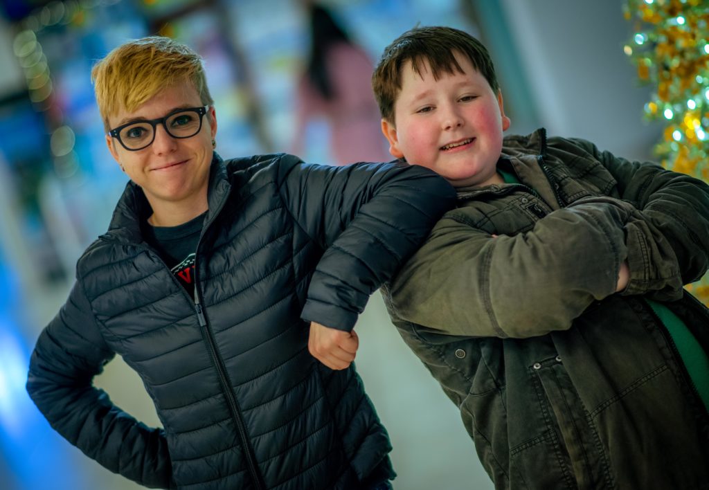 two people smiling at camera leaning on each other