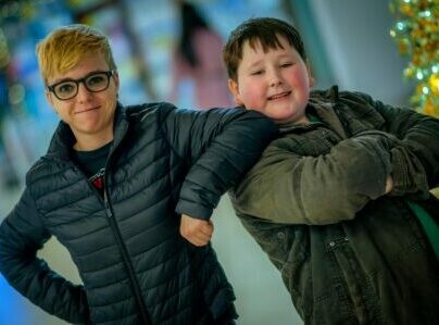 two people smiling at camera leaning on each other