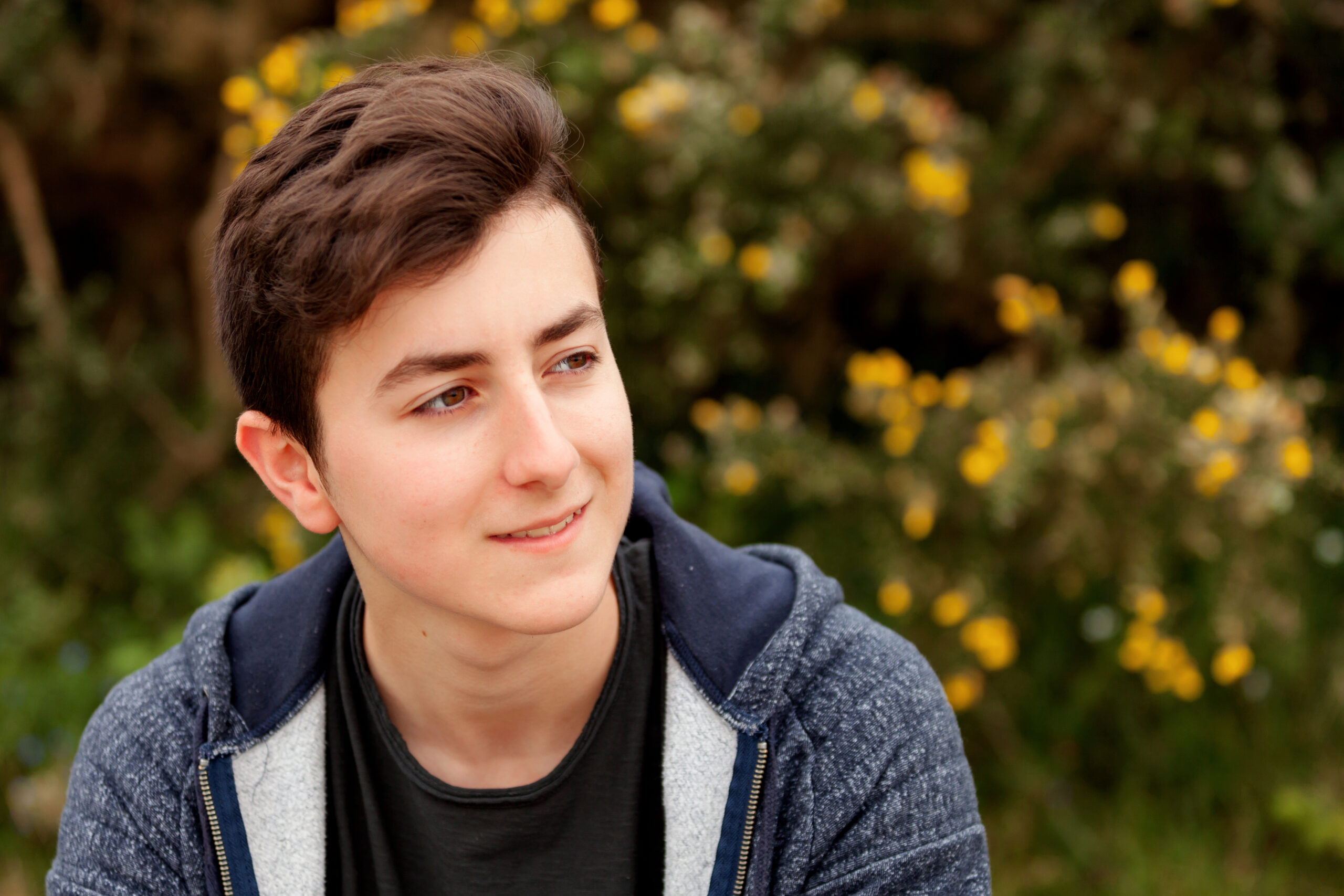 Attractive,Teenager,Guy,In,A,Park,With,Green,Plants,Of